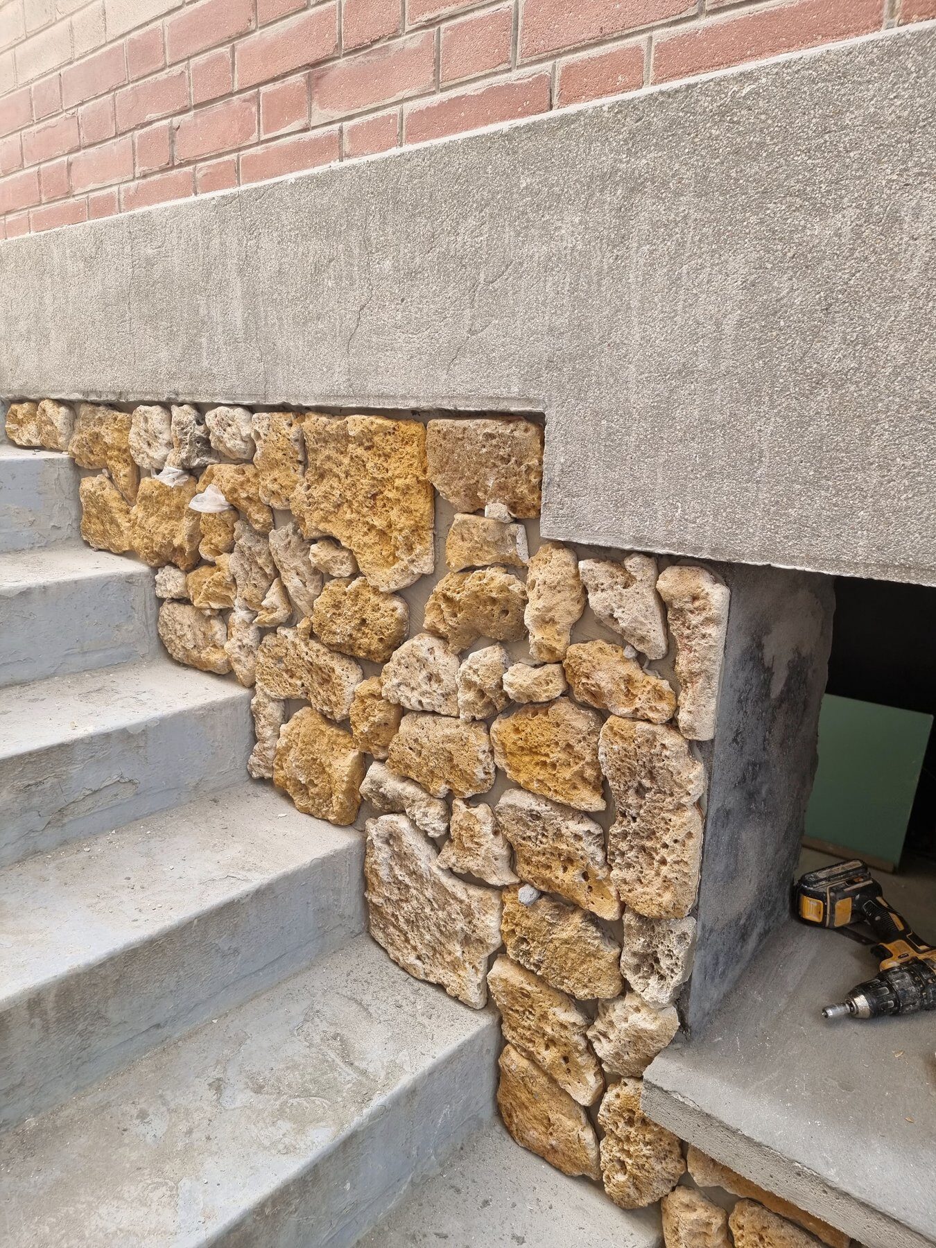 Détail du parement en pierre autour d'un accès pendant les travaux