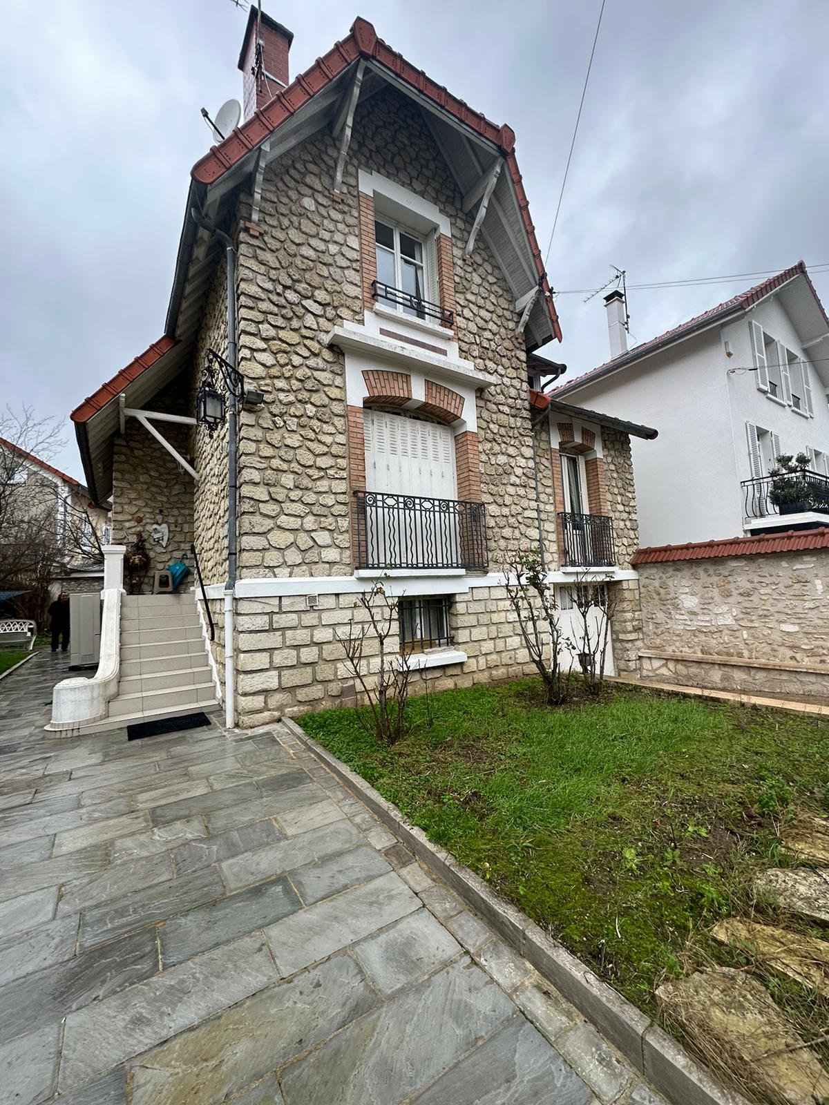 Façade de maison en pierre rénovée, vue depuis le jardin